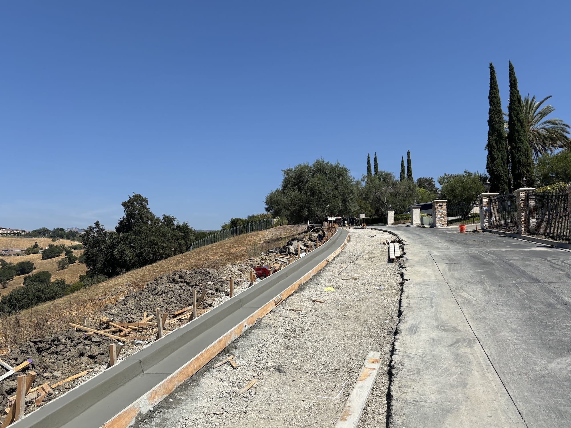 after photo, the finished curb line running along the fence toward the gate